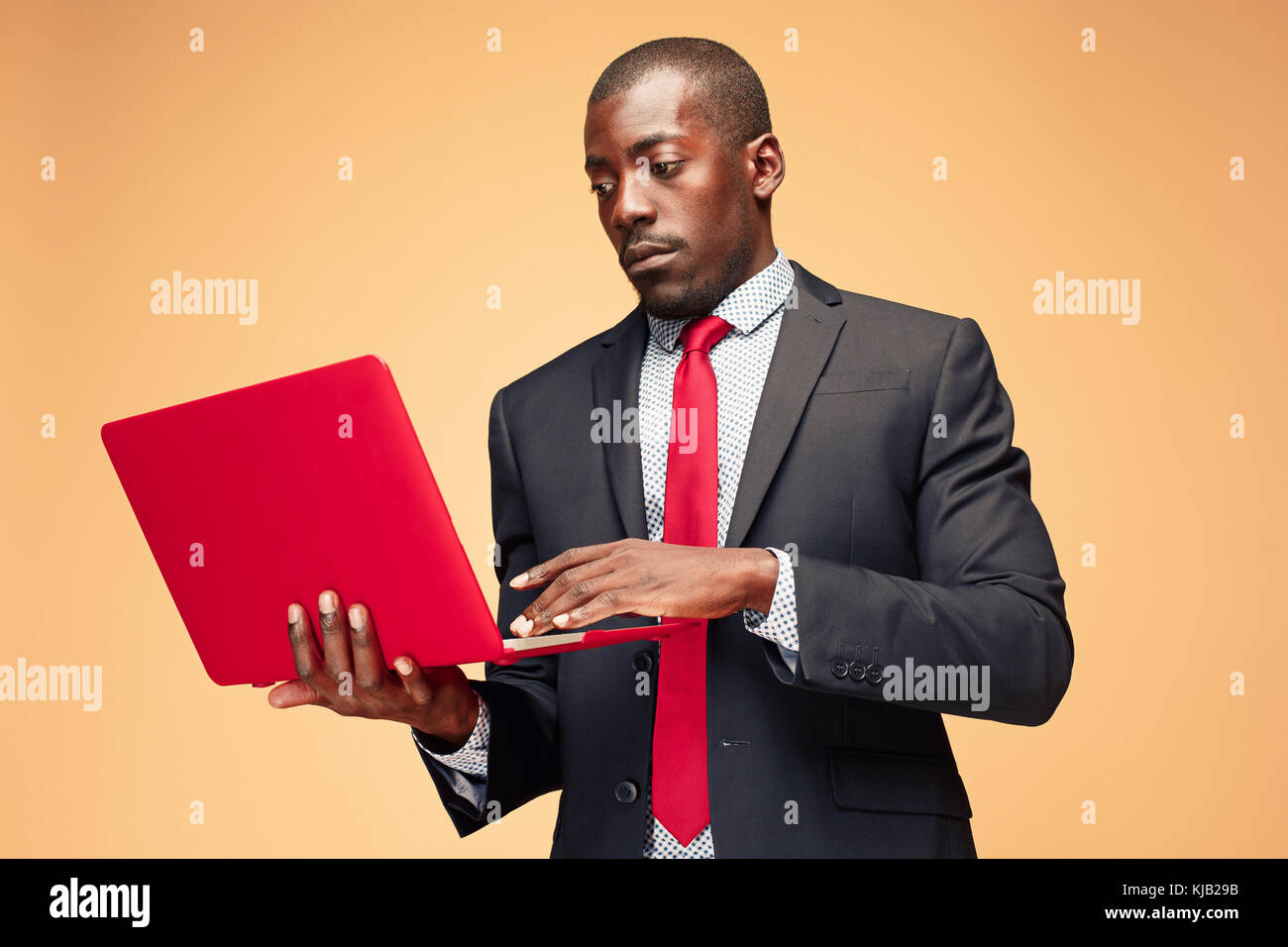 Handsome Afro American man sitting and using a laptop Stock Photo - Alamy