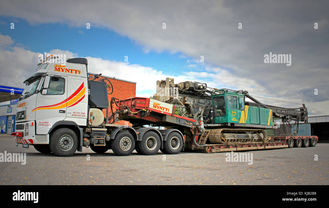 TURKU, FINLAND - SEPTEMBER 15, 2013: Volvo FH16 hauls a pile driver on a double drop deck trailer. A pile driver is a mechanical device used to drive  Stock Photo