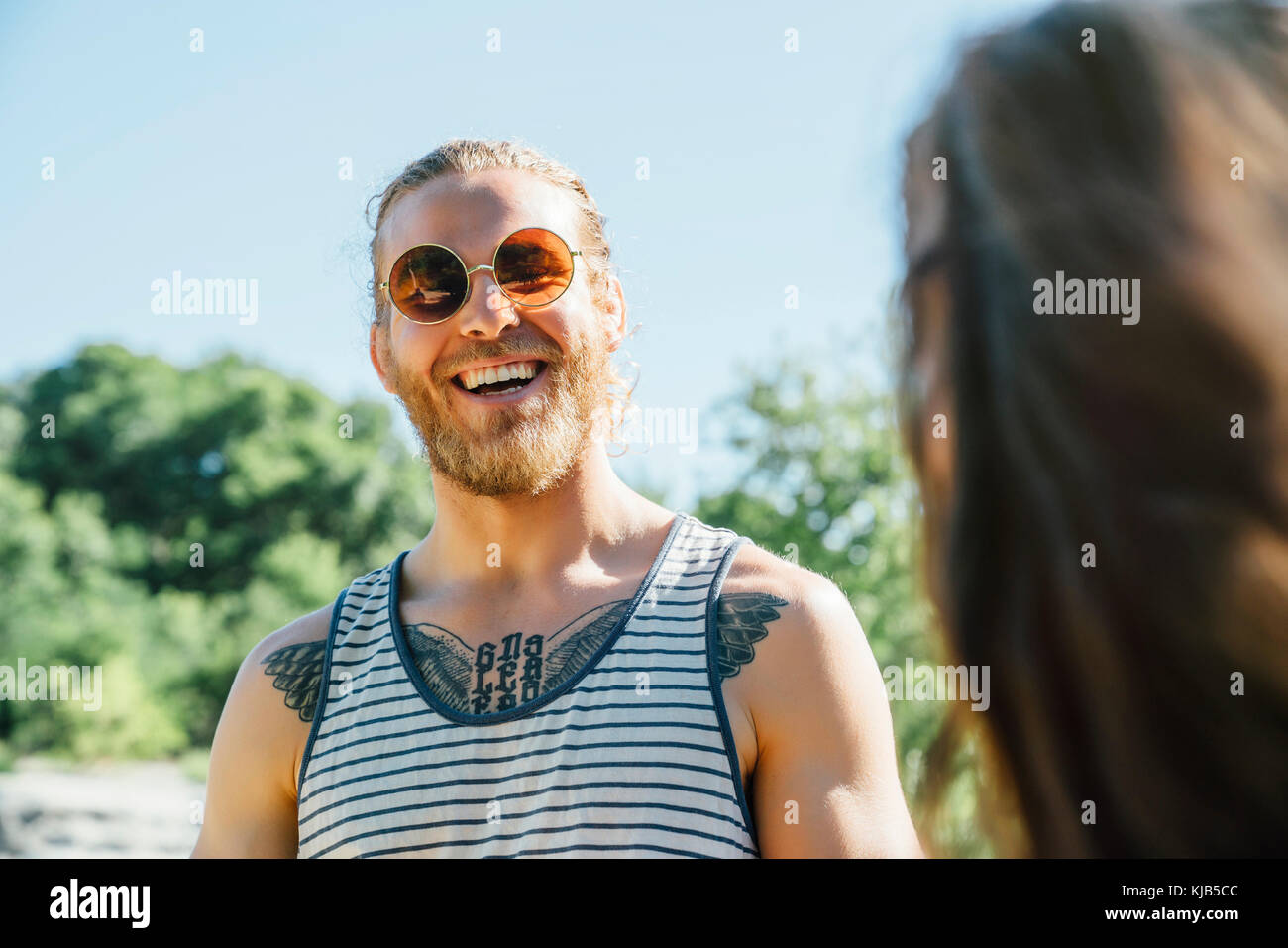 Caucasian man with chest tattoo laughing outdoors Stock Photo