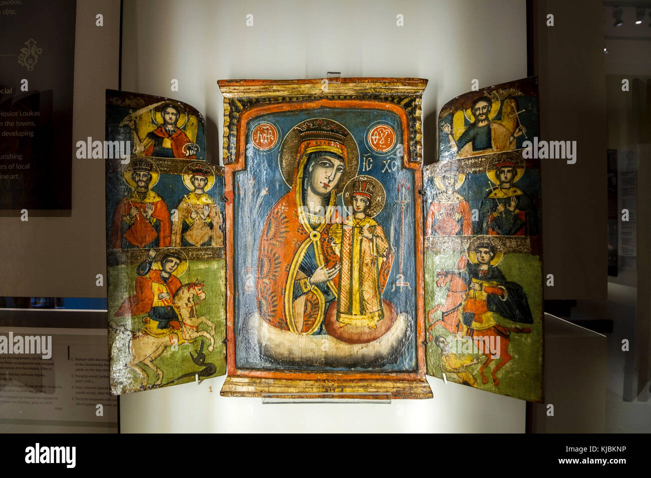 Wooden triptych with representation of christian orthodox religious scenes. In the middle there is Holy Mary holding newborn Jesus Christ. Stock Photo