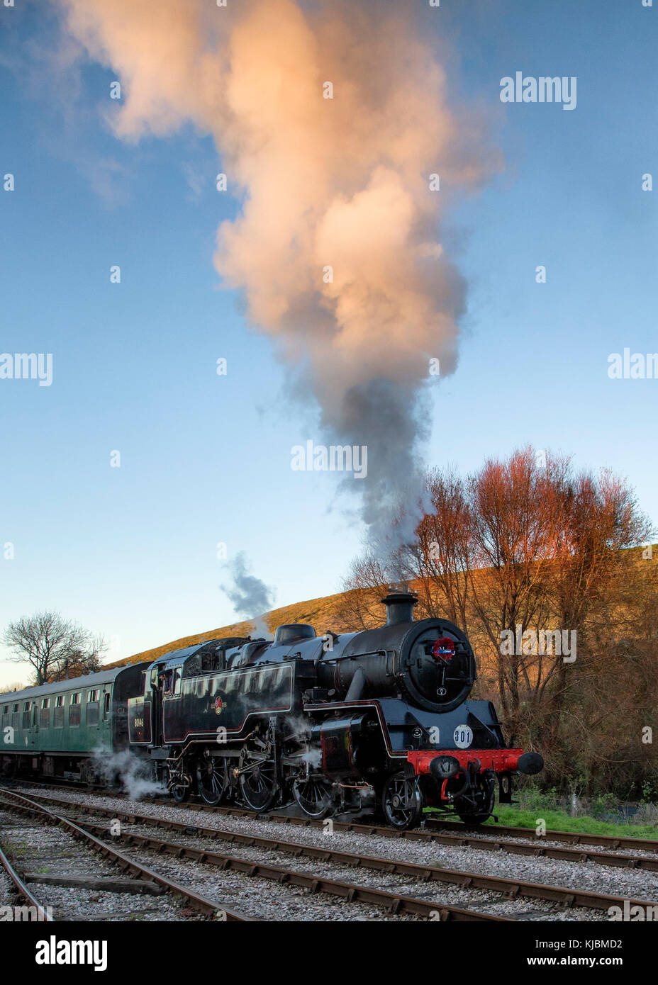 BR Standard Class 4 2-6-4T steam locomotive No.80146 hauls a passenger train out of Corfe Castle Station on an autumn evening Stock Photo