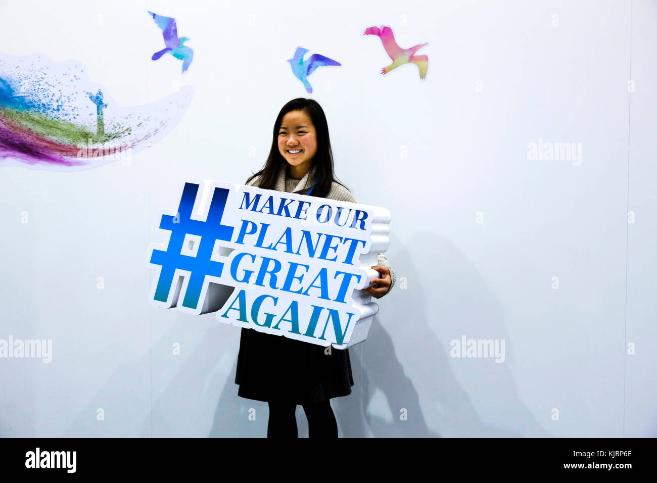 Bonn, Germany, November 17, 2017: Chinese hostess holds a banner 'Make our planet great again' at the COP23 Fiji conference. COP23 is organized by UN  Stock Photo