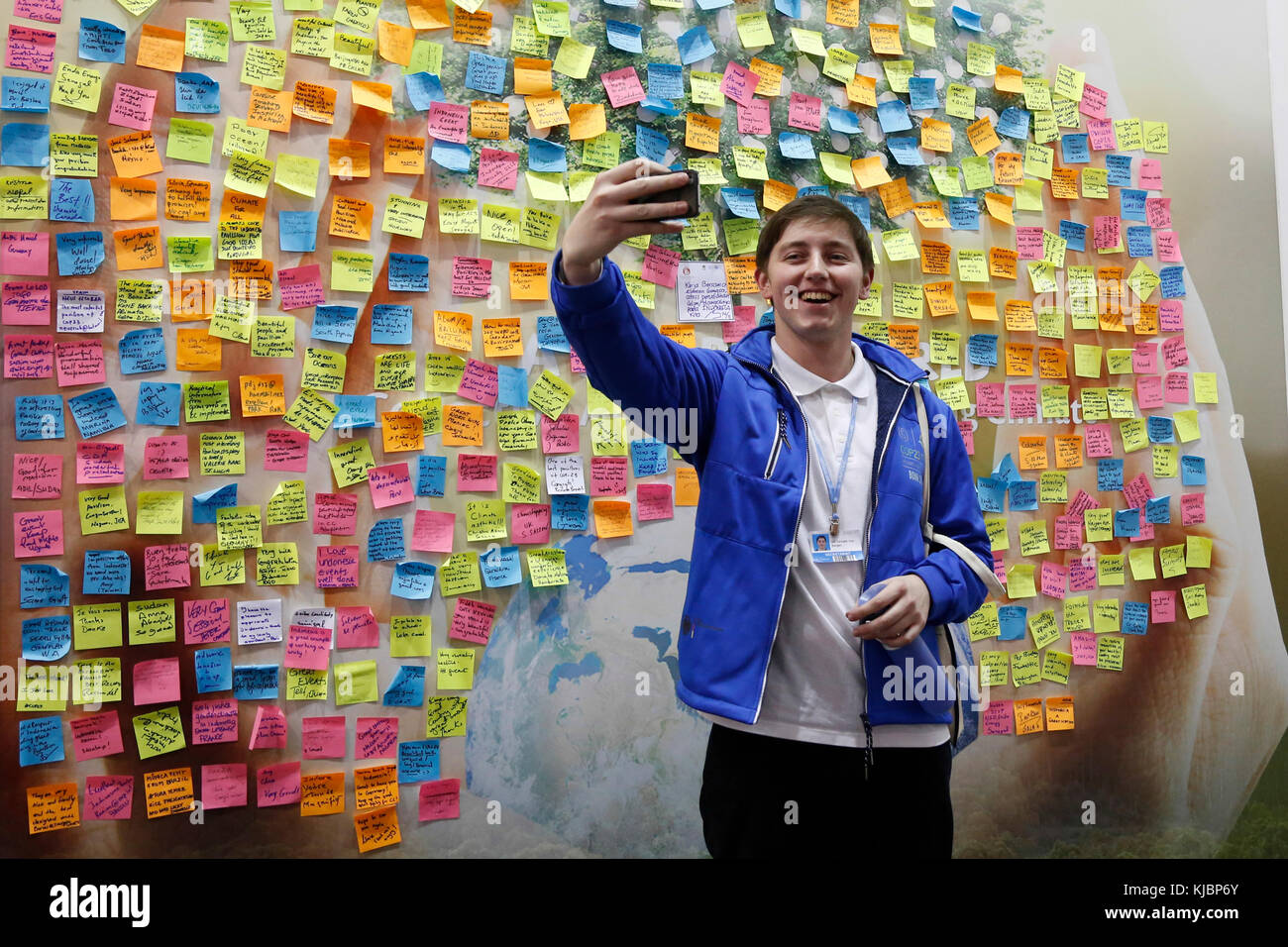 Boy taking selfie in front of a board full of environmental messages at the COP23 Fiji panel in Bonn, Germany on the 15th of November 2017. COP23 is o Stock Photo