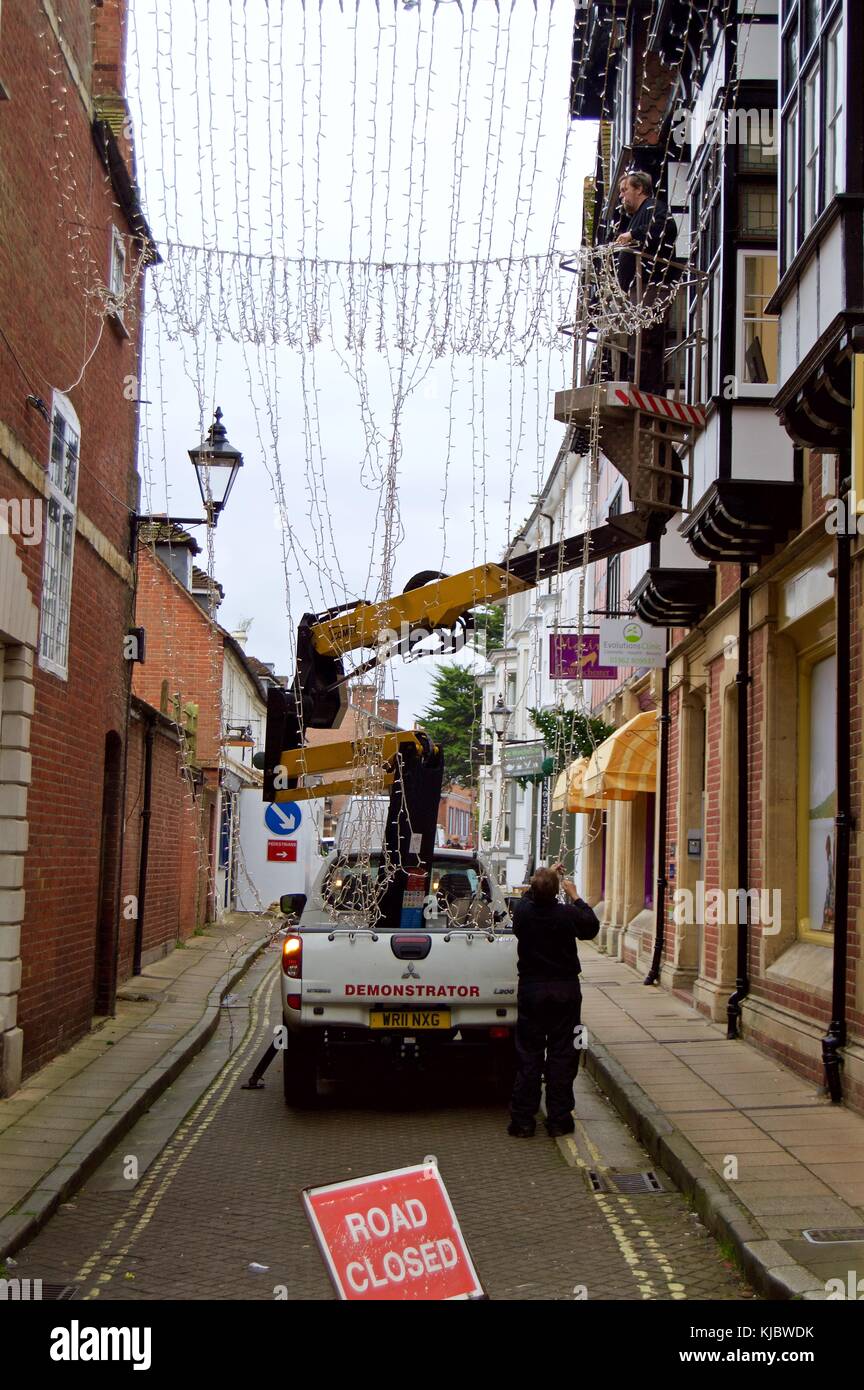 Two men putting up Christmas lights on Winchester High Street from cherry picker, Winchester, UK Stock Photo