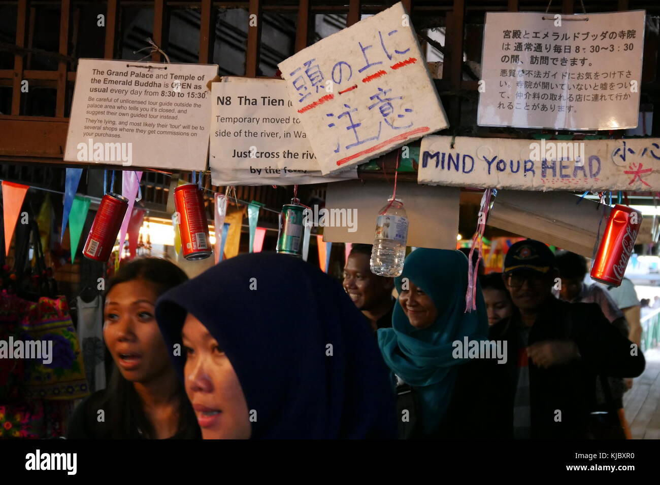A crowd is walking below instructions for tourists at one of the piers along the Chao Praya, Bangkok, Thailand. Stock Photo