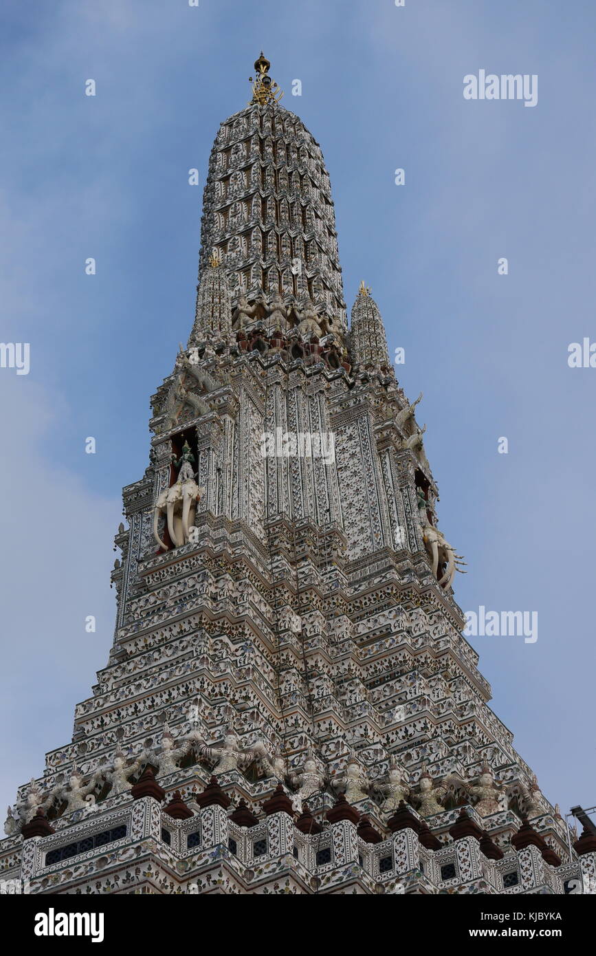 The main prang or stupa of Wat Arun, the Temple of Dawn in Bangkok features four statues of the Hindu god Indra atop the three-headed elephant Erawan. Stock Photo