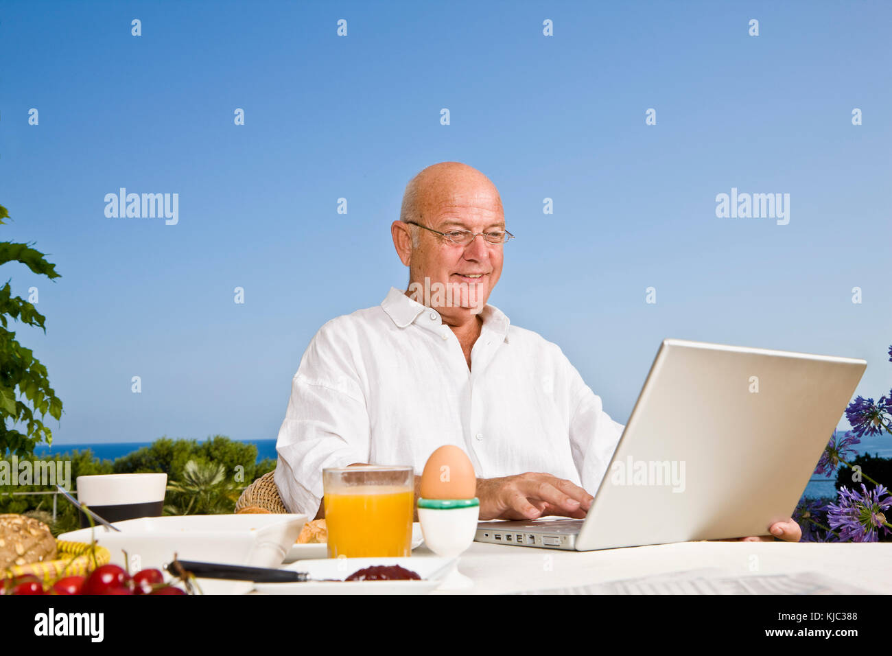Man on Patio Eating Breakfast, Using Laptop Computer Stock Photo - Alamy