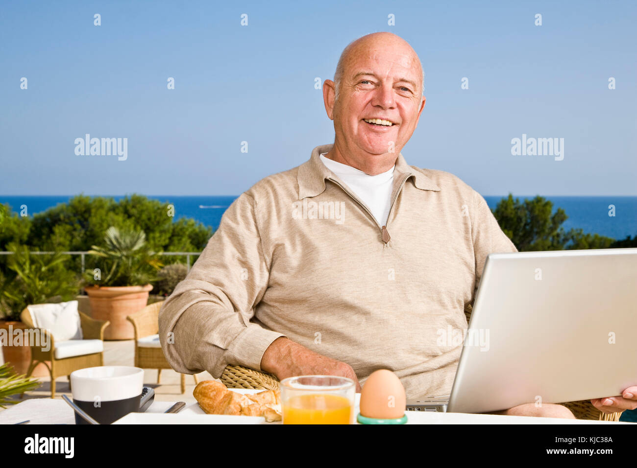Man on Patio Eating Breakfast, Using Laptop Computer Stock Photo - Alamy