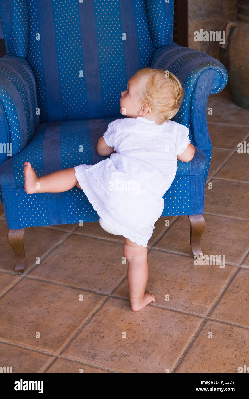 Toddler Climbing into Armchair Stock Photo Alamy