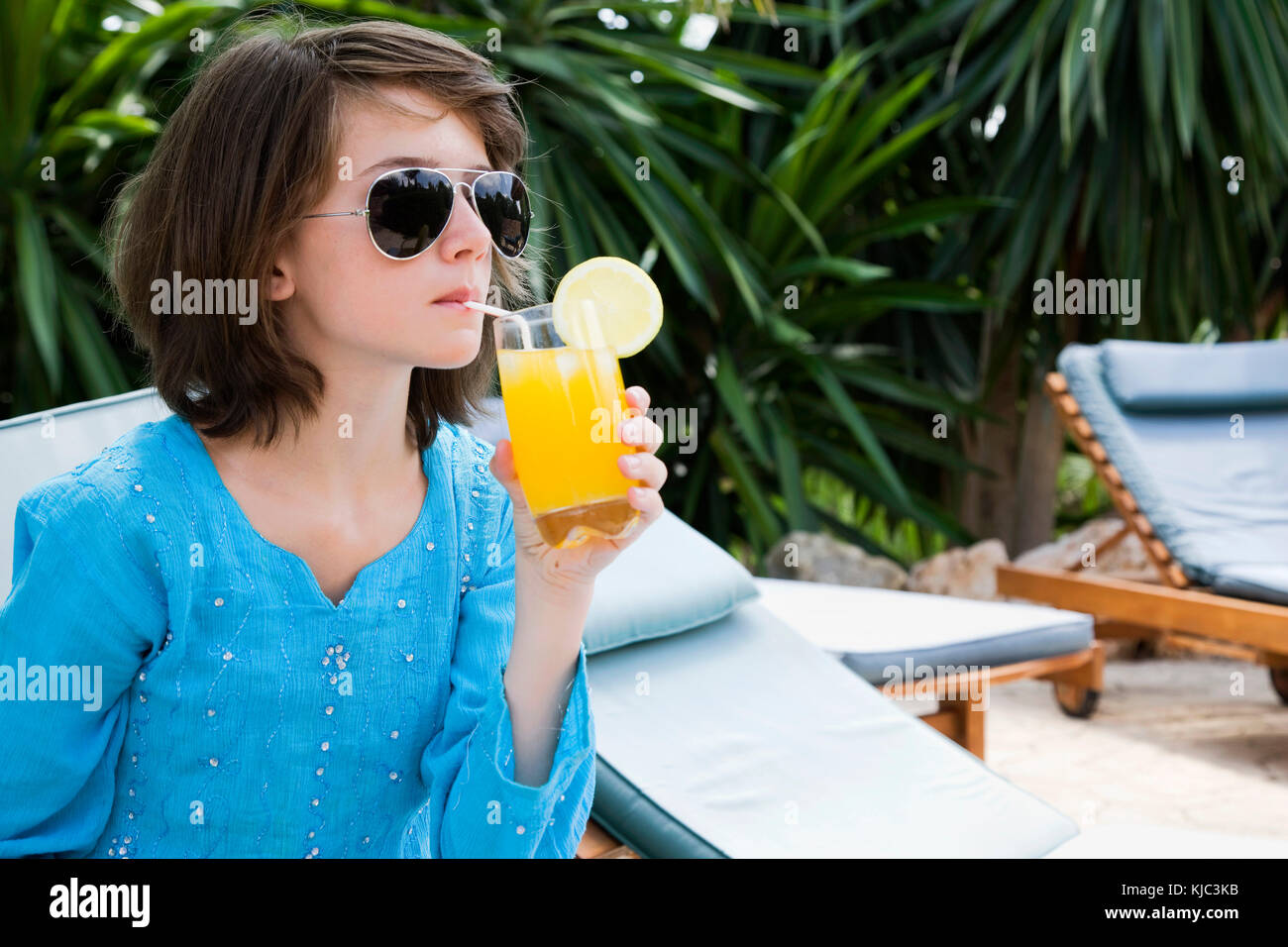 Young Girl Relaxing by the Pool With a Drink Stock Photo - Alamy