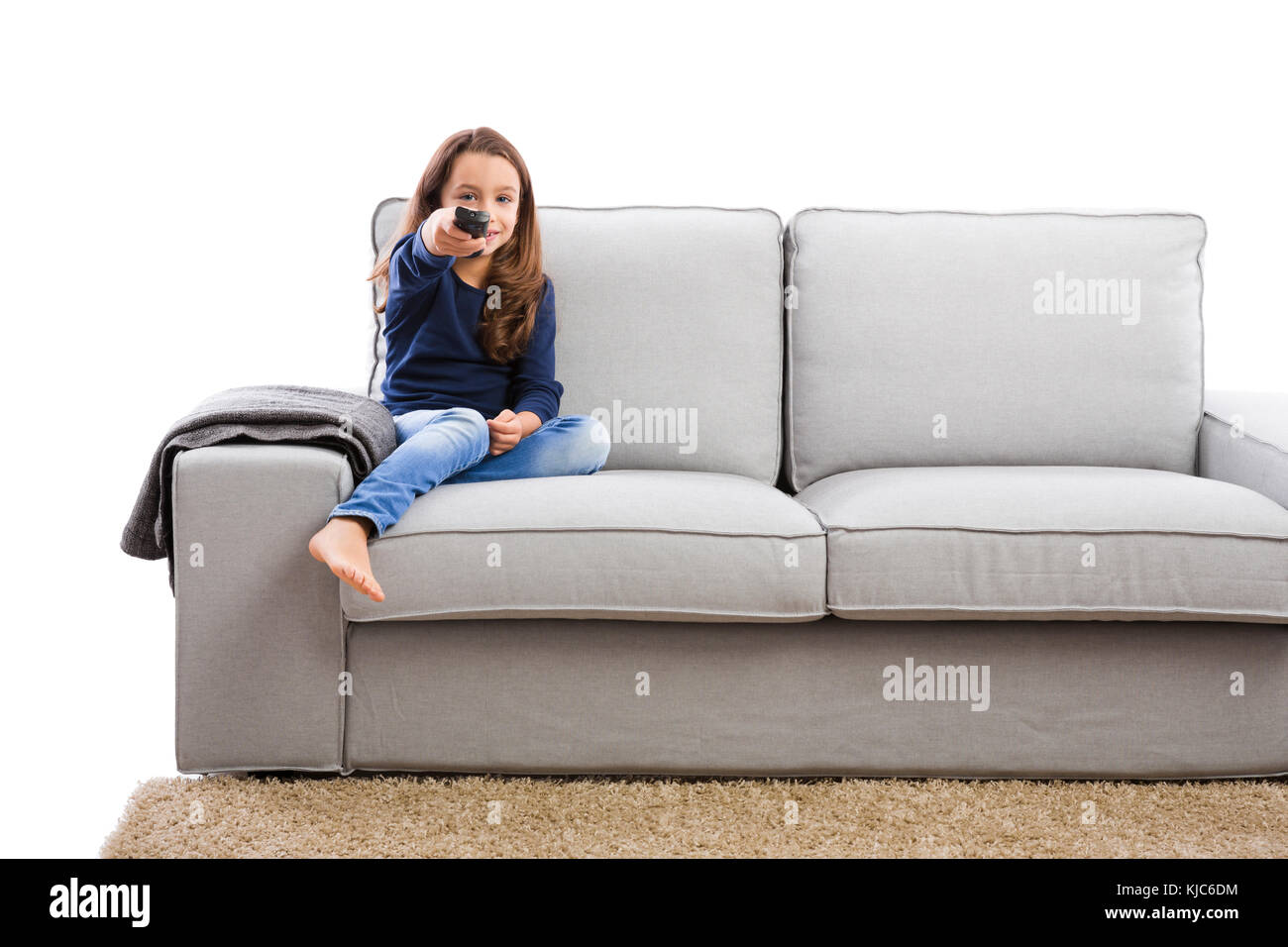 Little girl holding a TV remote control Stock Photo
