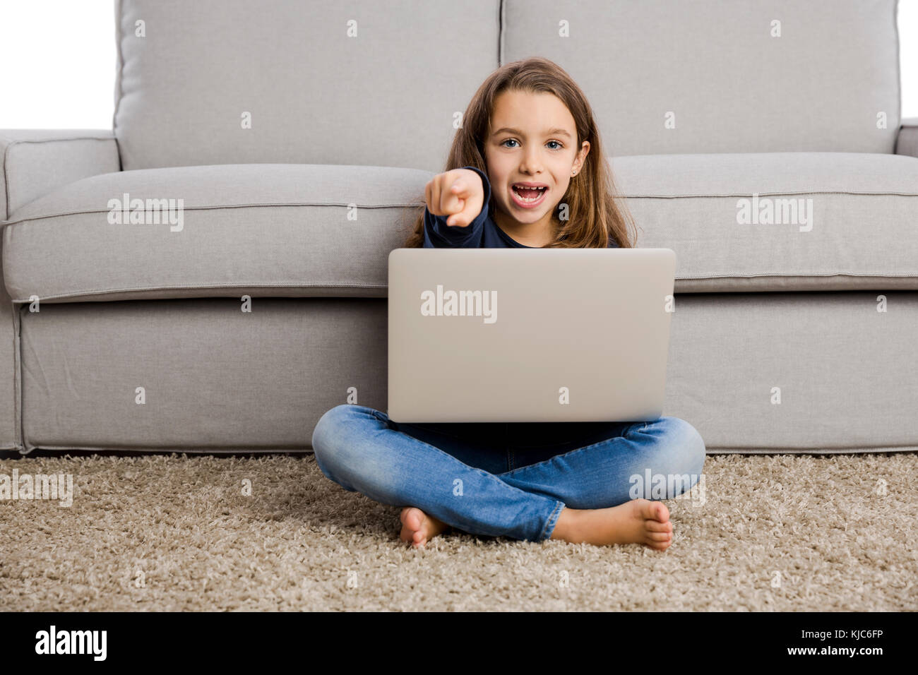 Happy little girl at home working with a laptop Stock Photo - Alamy