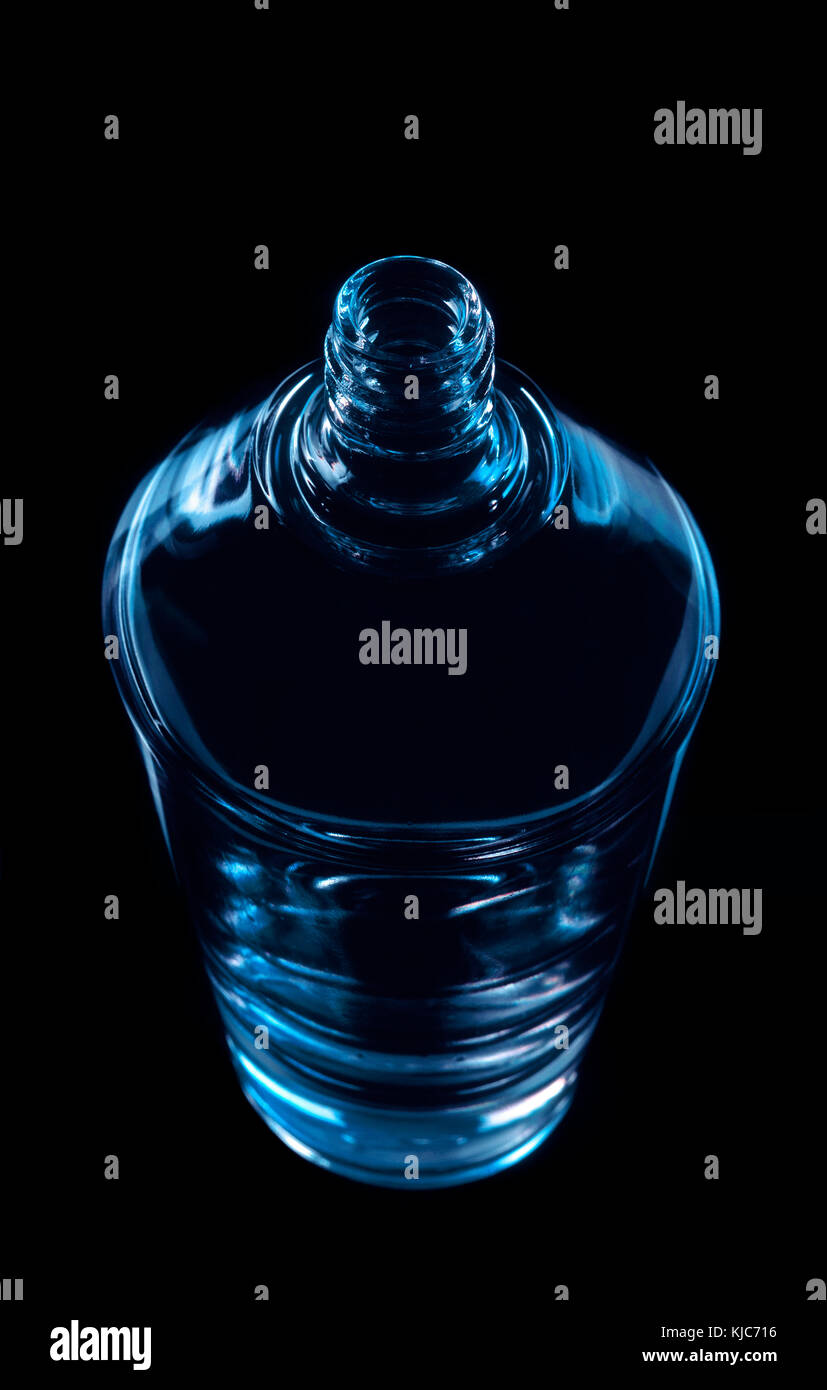 Perfumery glass bottle. Blue color on black background Stock Photo