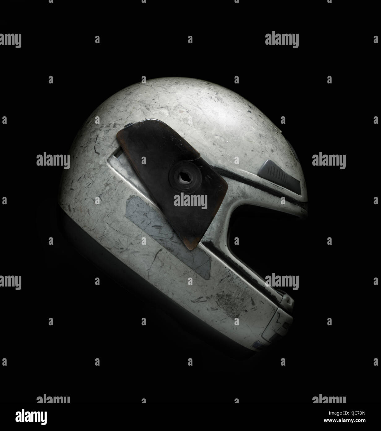 Broken and scratched motorcycle helmet against black background. Clipping path. Stock Photo