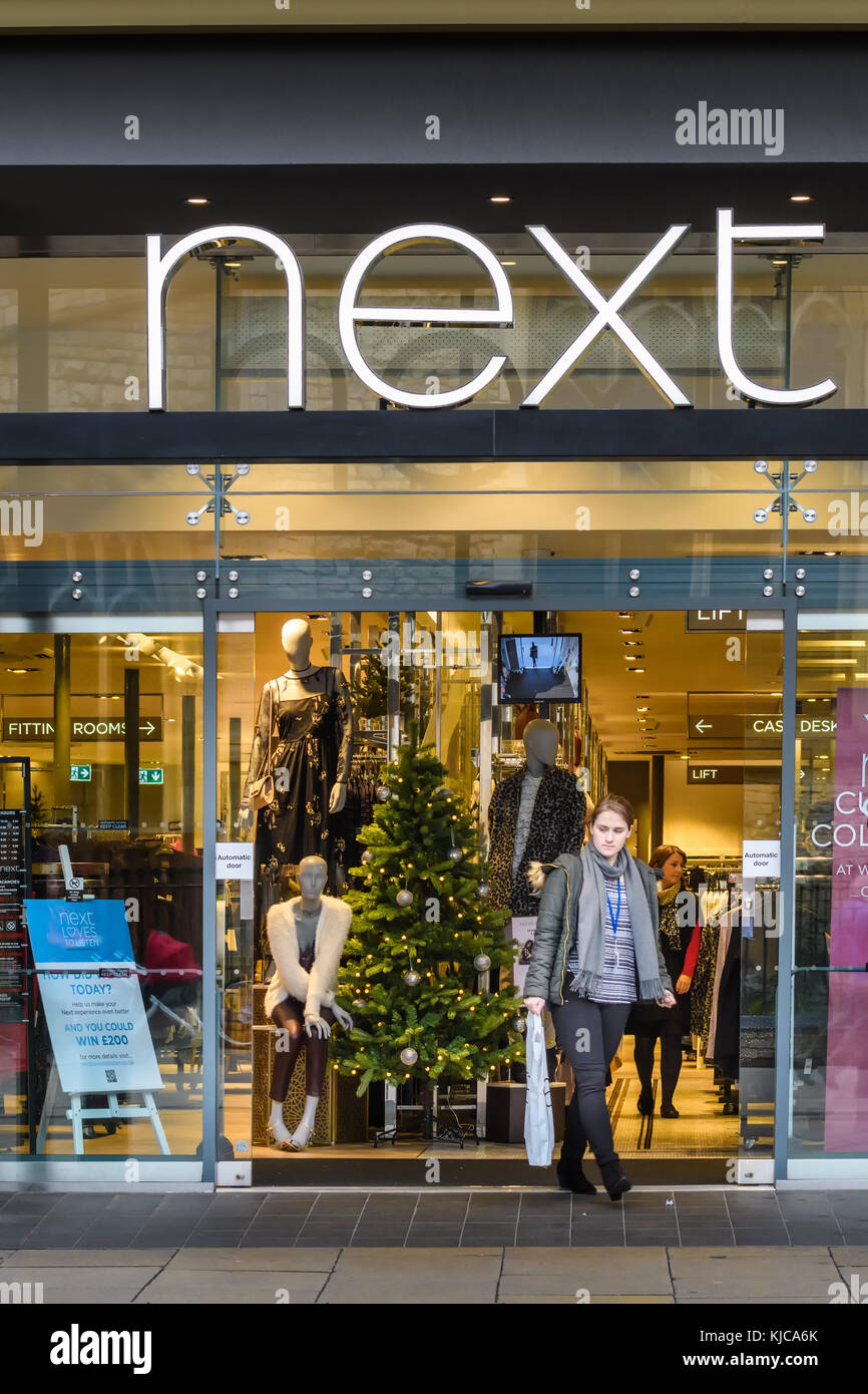 Christmas tree on display at the entrance to the Next shop in the shopping area at the centre of the town of Cambridge, England. Stock Photo