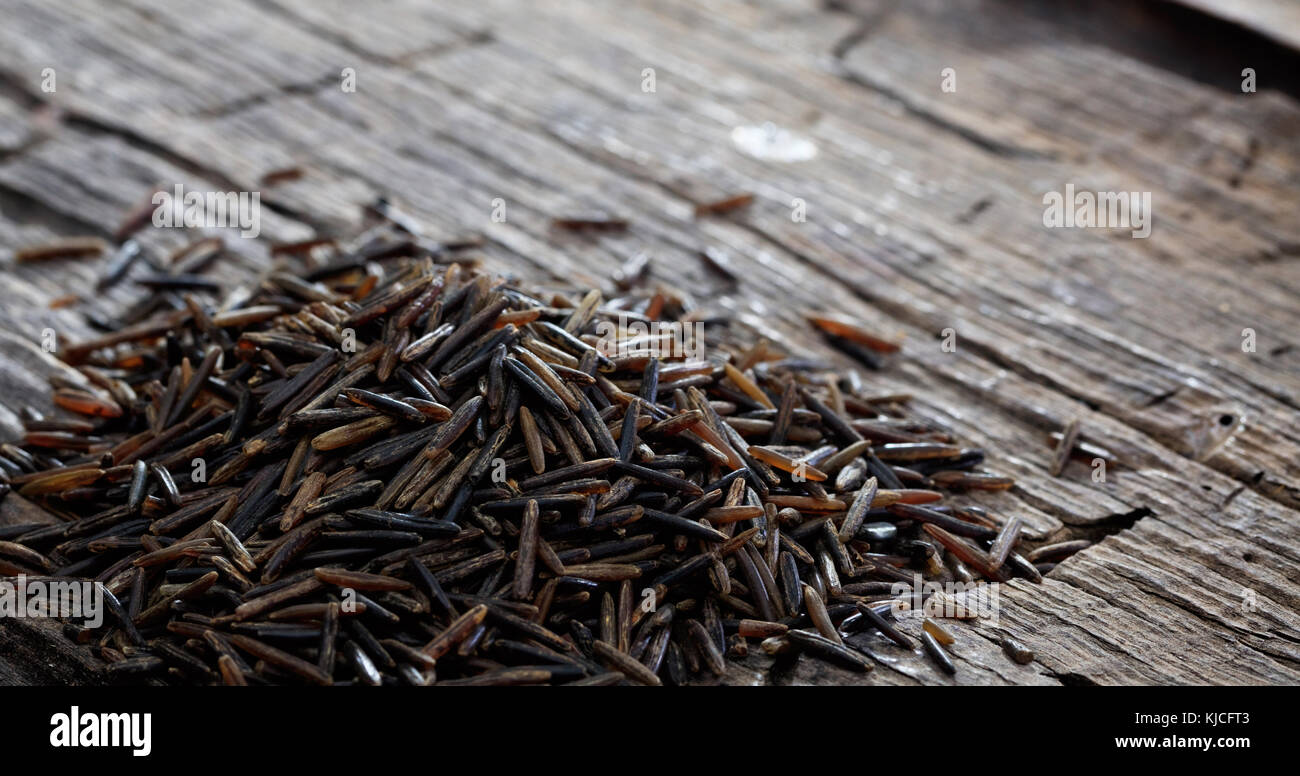 Heap of raw wild rice on an old wooden table, copy space Stock Photo ...
