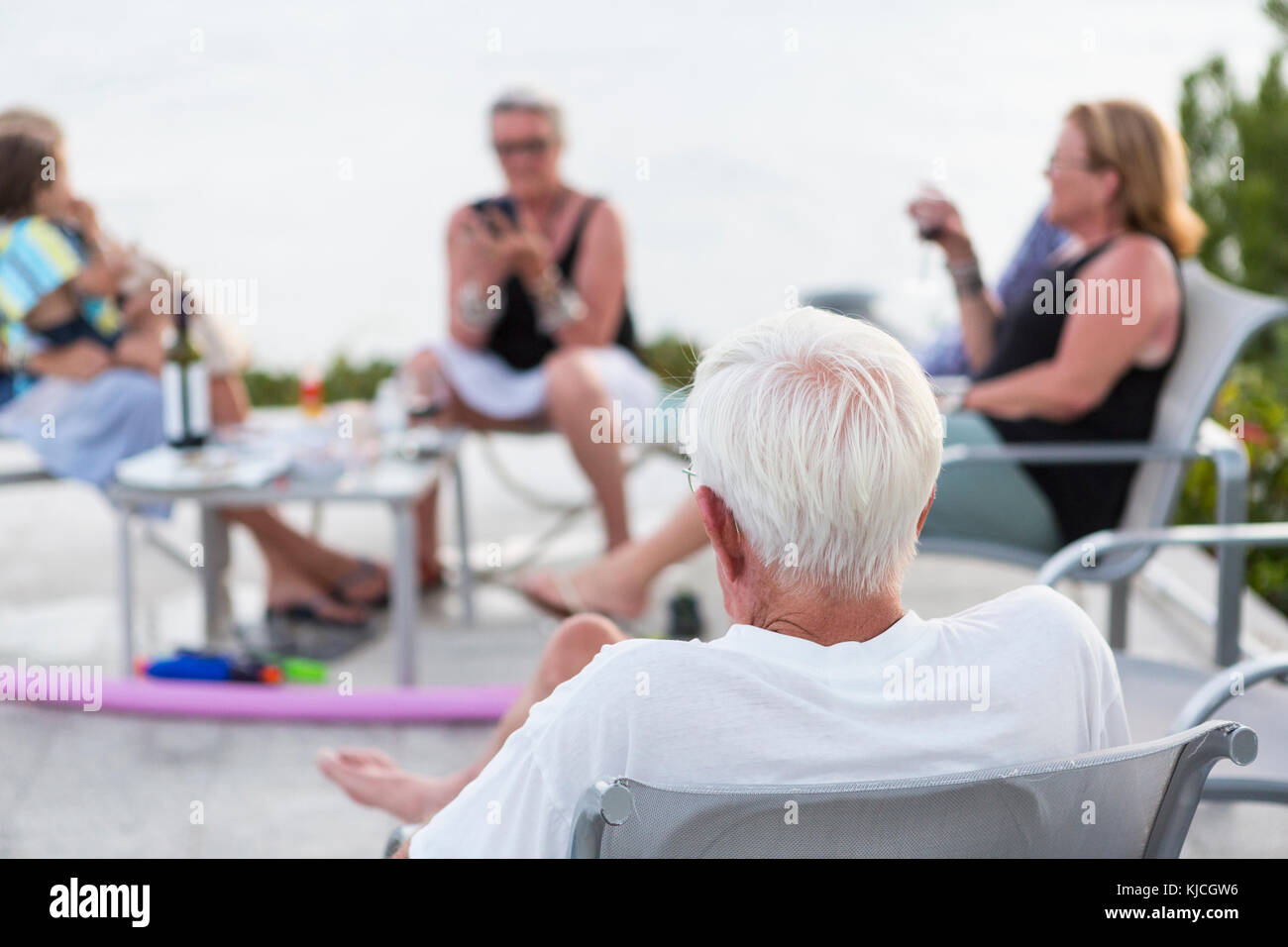 Caucasian people relaxing on patio Stock Photo