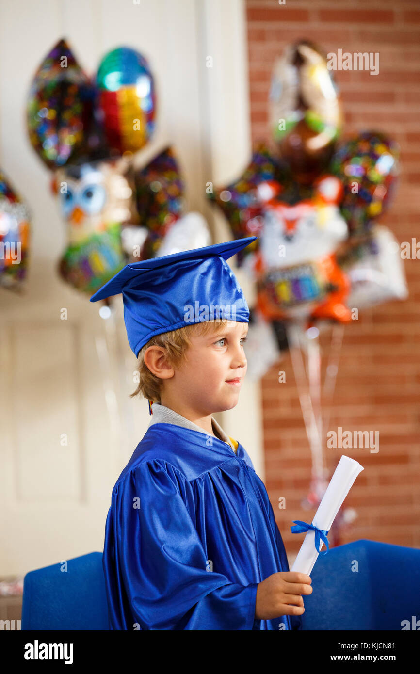 Caucasian boy wearing graduation robe holding diploma Stock Photo Alamy