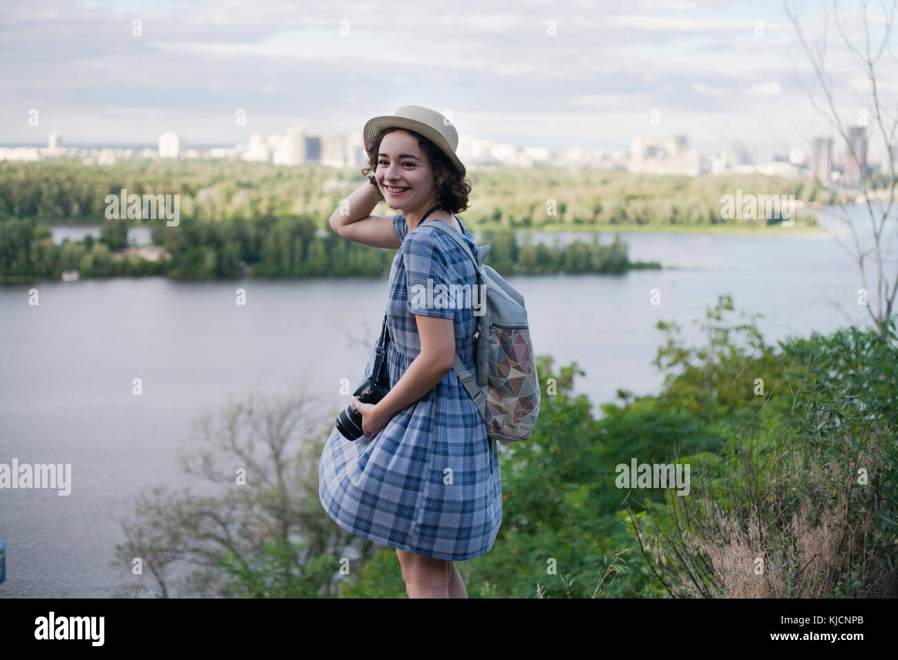 Portrait of a Caucasian woman carrying camera near river Stock Photo