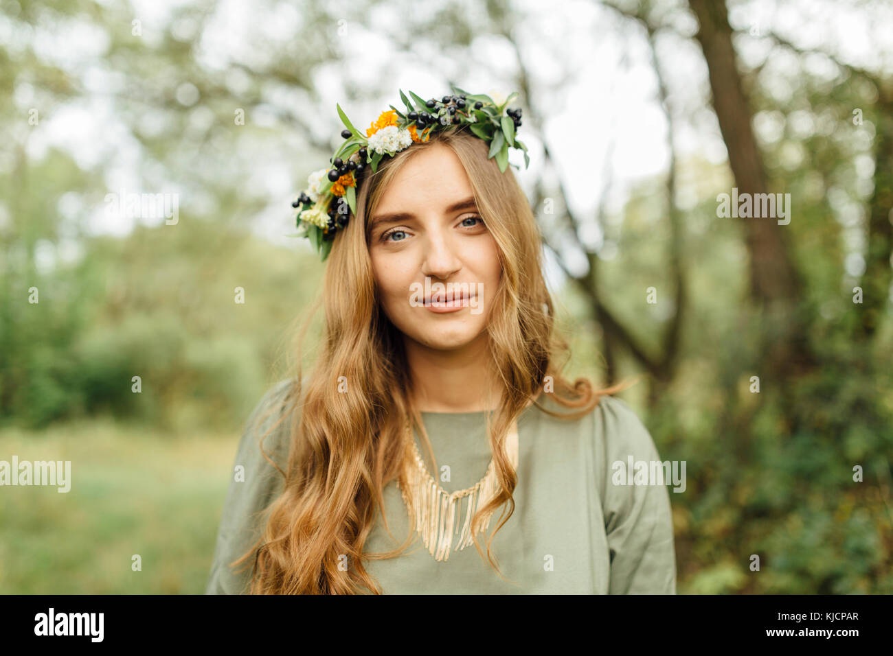 Middle Eastern woman wearing flower crown in woods Stock Photo