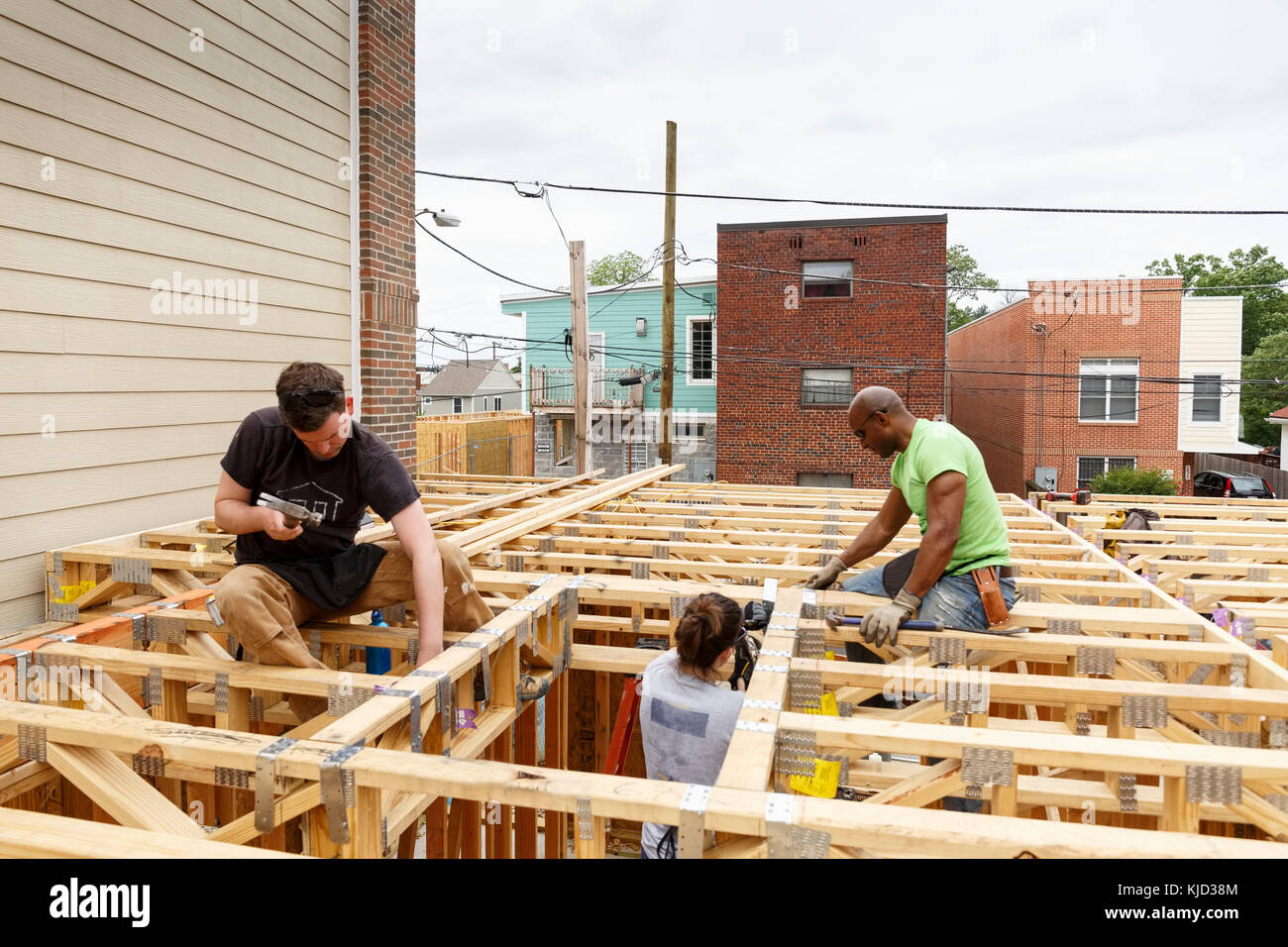 Volunteers hammering nails at construction site Stock Photo Alamy