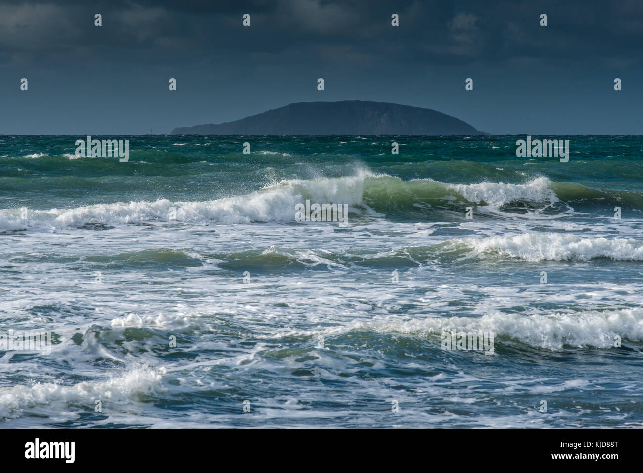 Waves crash onto Porth Neigwl beach, with Bardsey Island in the distance, near Abersoch, Llyn Penninsula, Gwynedd, Wales Stock Photo