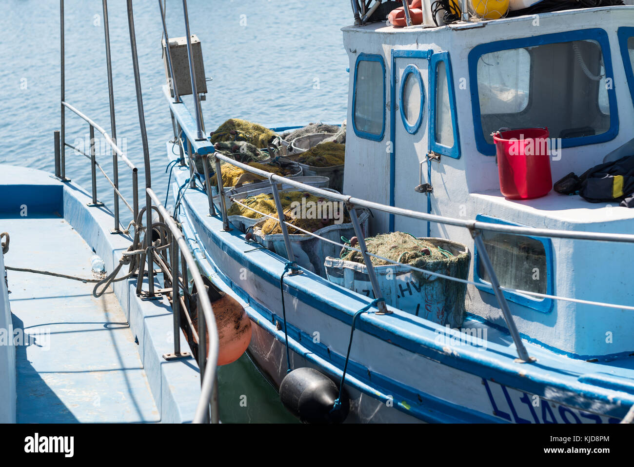 Fishing boat detail with chair, wheel and nets in bags - in Fishing pier,  Larnaca, Cyprus Stock Photo - Alamy