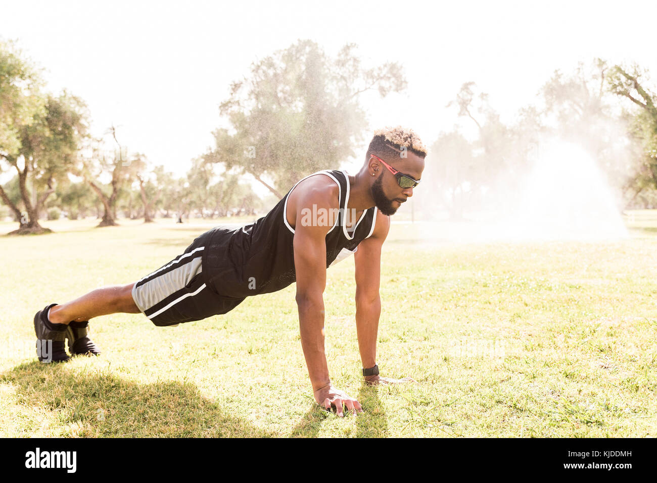 Black man doing push-ups in park Stock Photo - Alamy