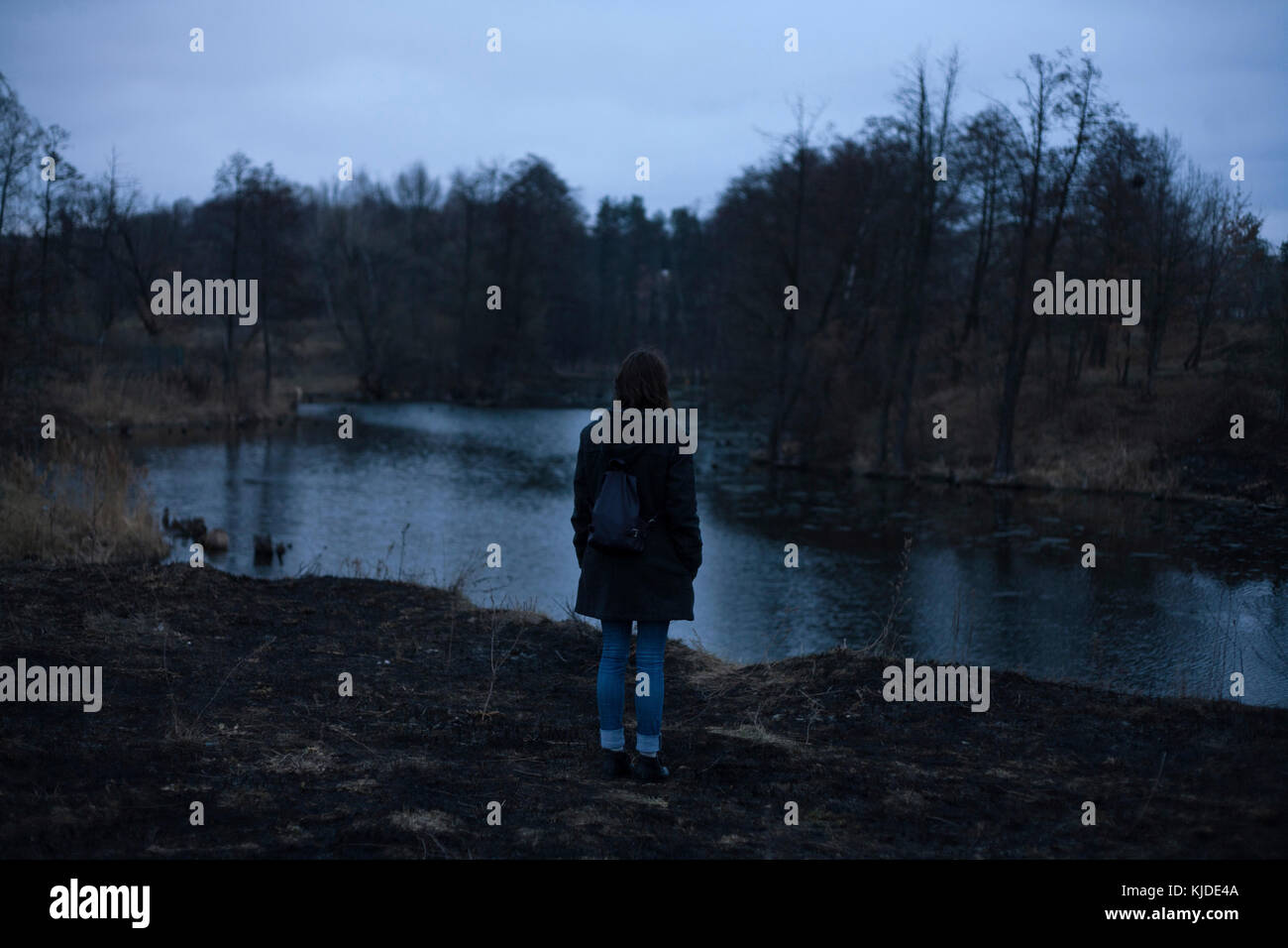 Caucasian woman standing near river at night Stock Photo - Alamy