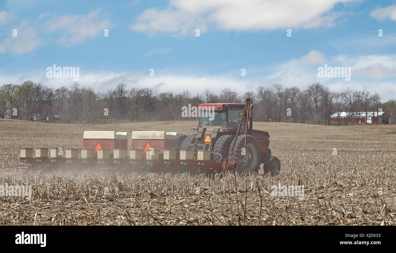 Tractor seeding corn in a farm field Stock Photo