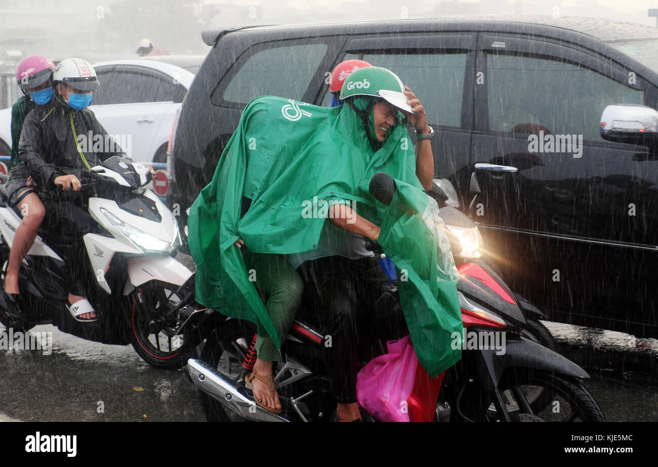 HO CHI MINH CITY, Vietnamese people wear raincoat ride motorcycle, difficult move in heavy rain, high wind from bad weather by tropical low pressure Stock Photo