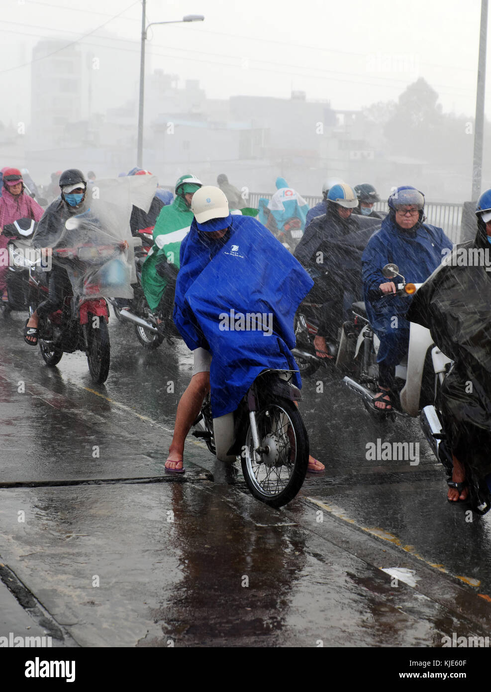 HO CHI MINH CITY, Asian people ride motorbike, difficult move in heavy rain, high wind from bad weather by tropical low pressure after storm, Vietnam Stock Photo