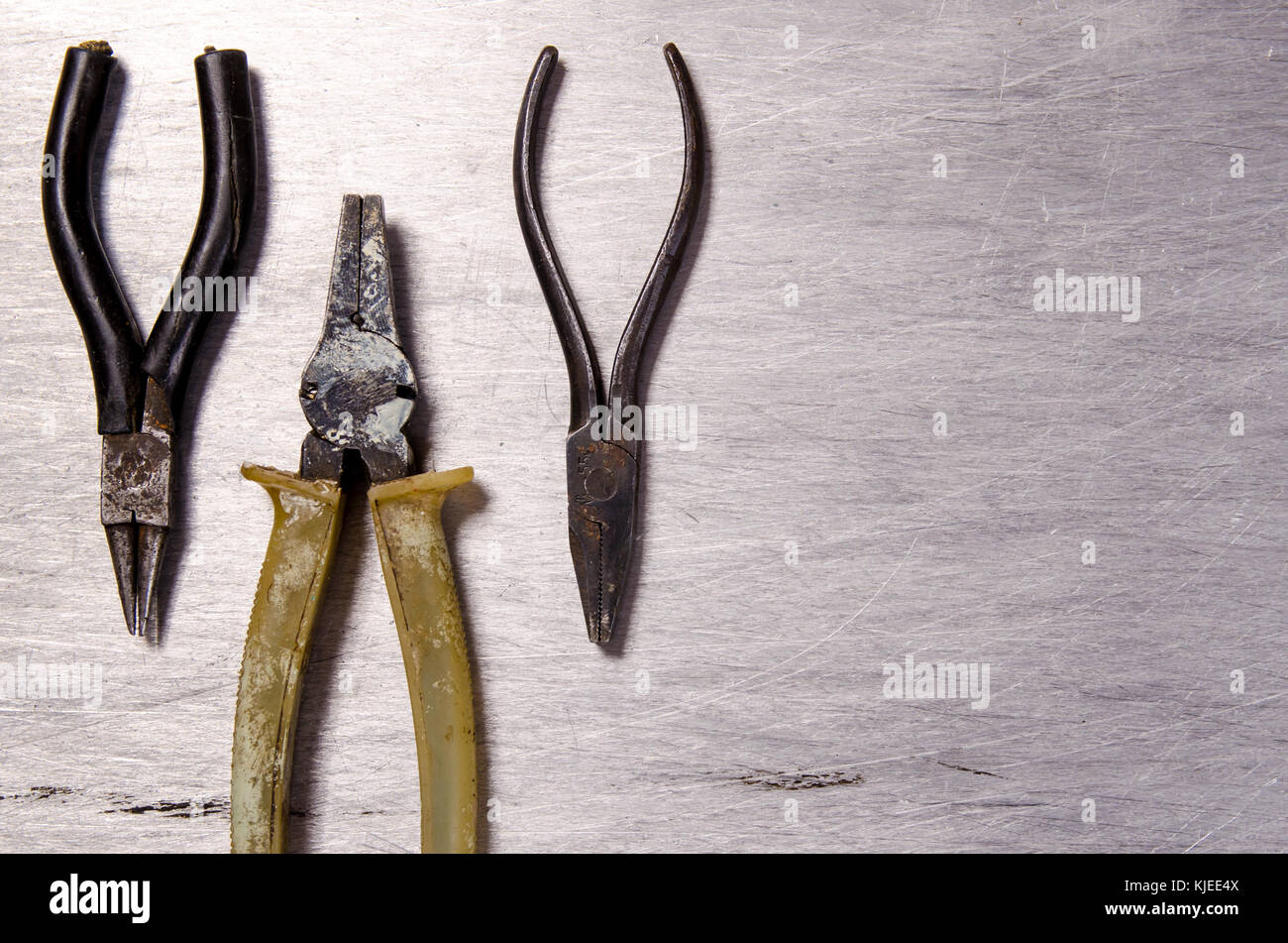 Pliers and round pliers on a metallic aluminum background Stock Photo