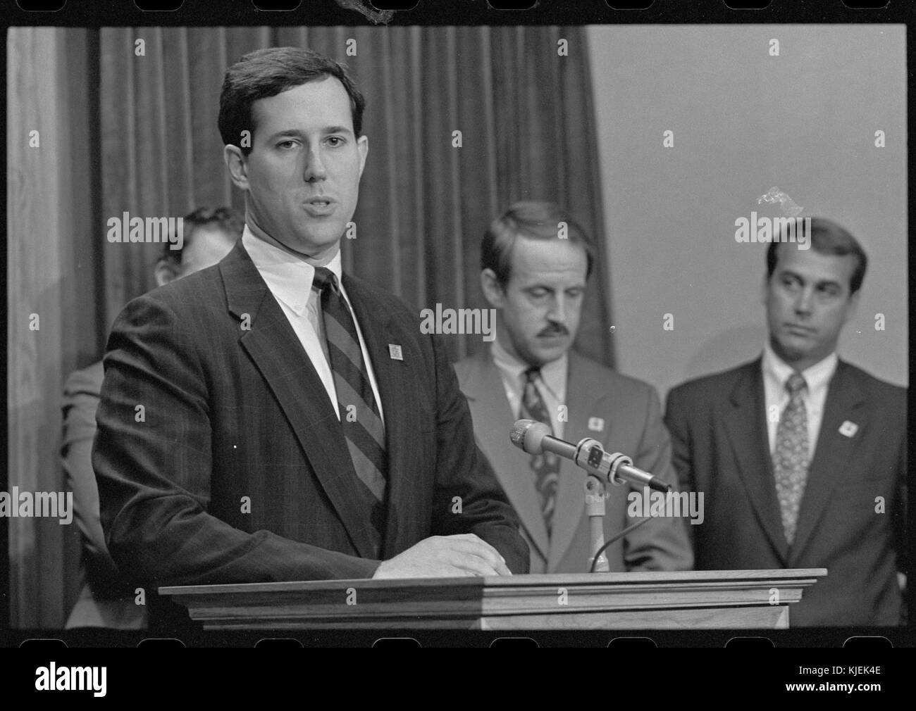 Representative Rick Santorum stands at a podium with Representatives John Boehner and Frank Riggs nearby Stock Photo
