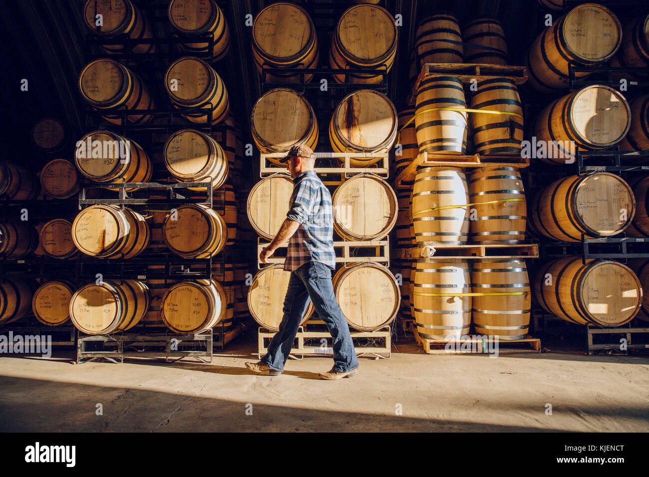 Caucasian man walking near barrels in distillery Stock Photo