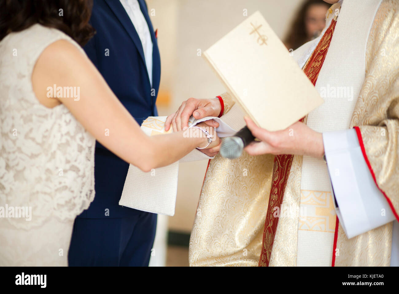 Priest and couple joining hands in wedding Stock Photo