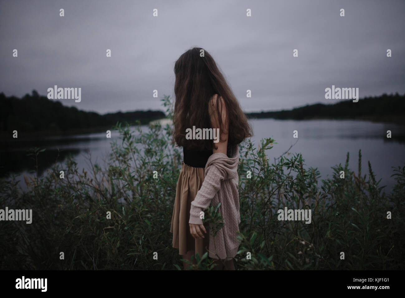 Caucasian woman standing near river Stock Photo - Alamy