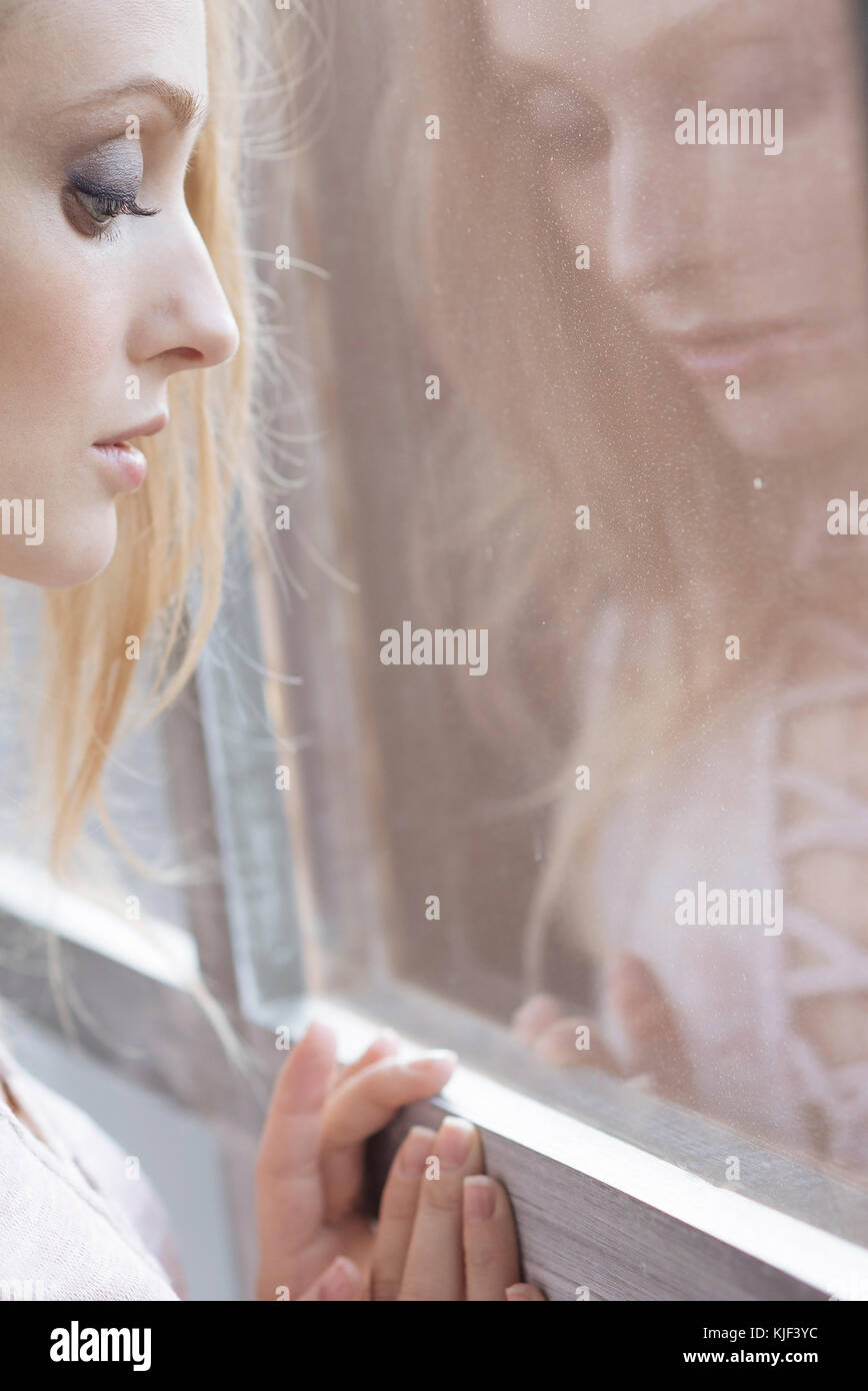 Reflection of Caucasian woman leaning on window Stock Photo