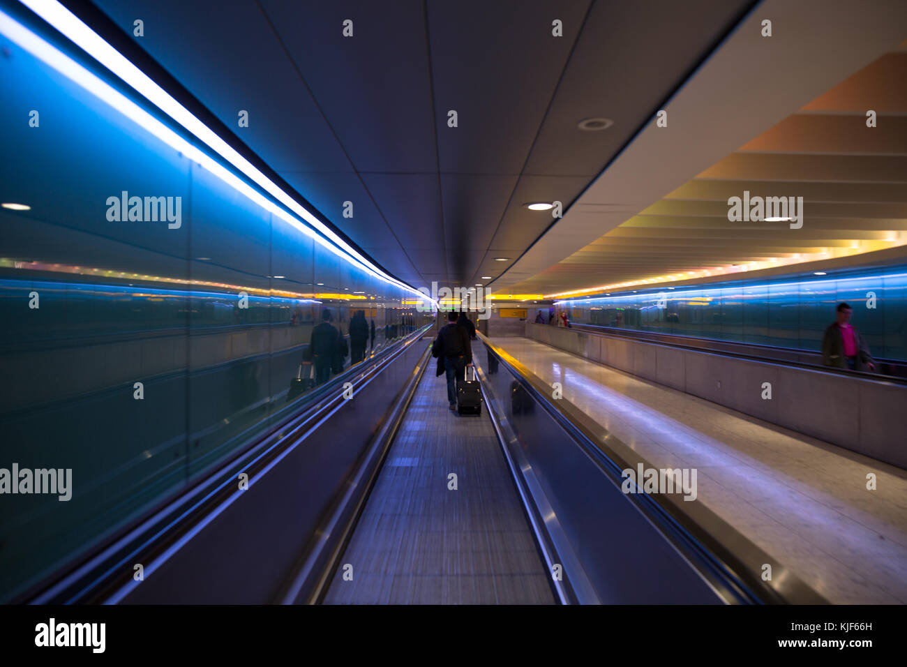 Lit moving walkway with blue and orange lights in London Heathrow Airport Stock Photo