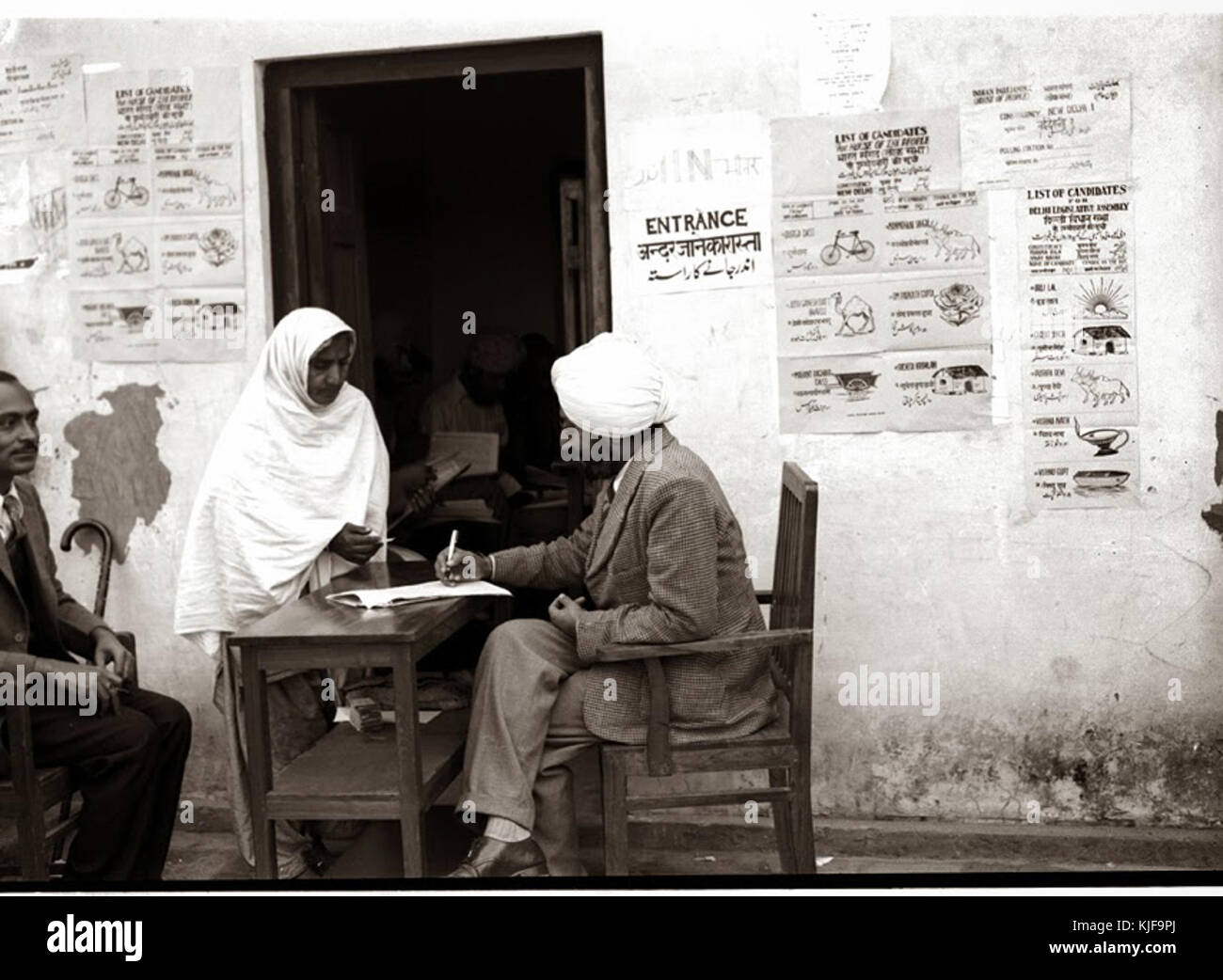 A refugee woman being given her ballot papers, at a polling station in Lajpat Nagar, 1952 Stock Photo