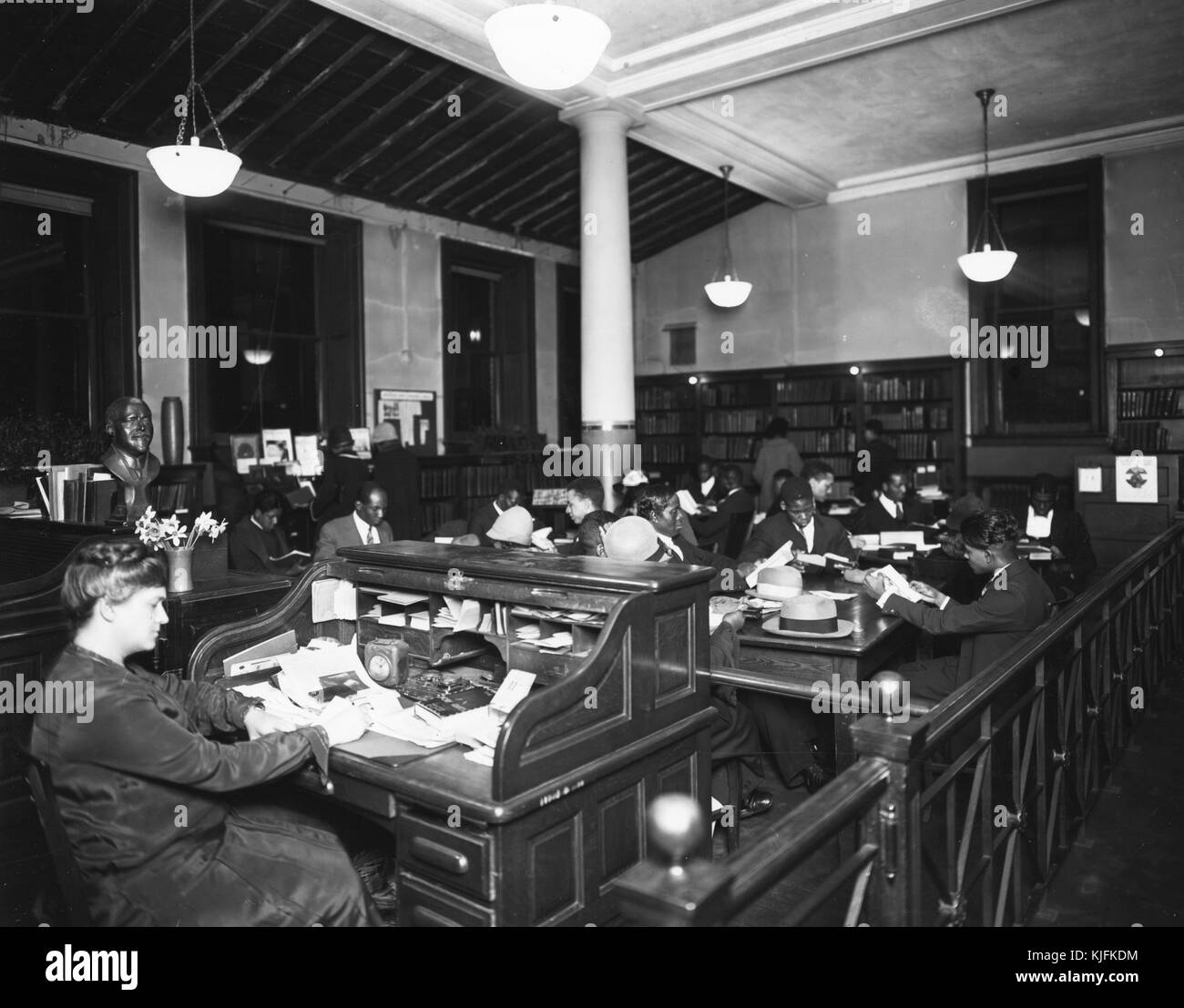 A photograph of Ernestine Rose working at the 135th Street branch of the New York City Public Library, she lead the library in activities that is credited with playing a large part in the Harlem Renaissance by having a book collection that connected the local black community to their history, they also organized events to connect readers with artists and performers, 1930. From the New York Public Library. Stock Photo
