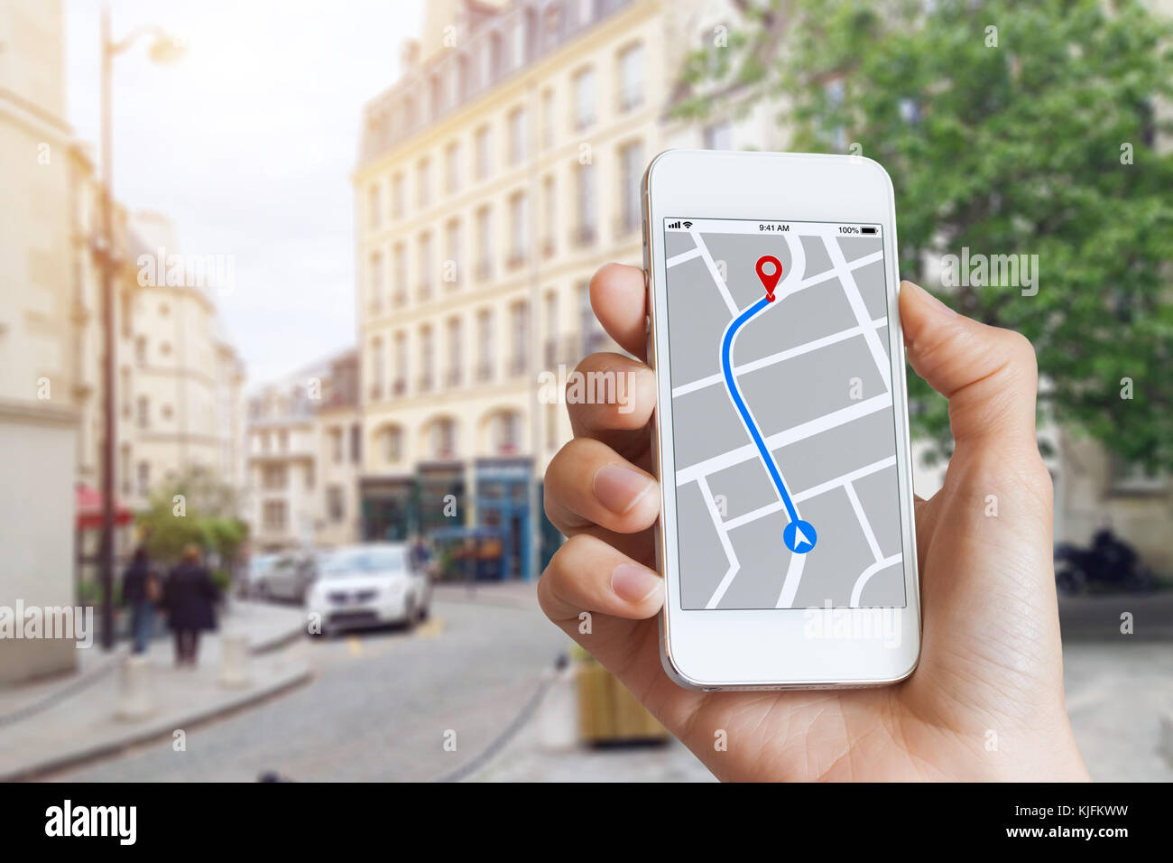 Tourist using GPS map navigation app on smartphone screen to get direction to destination address in the city streets, travel and technology Stock Photo
