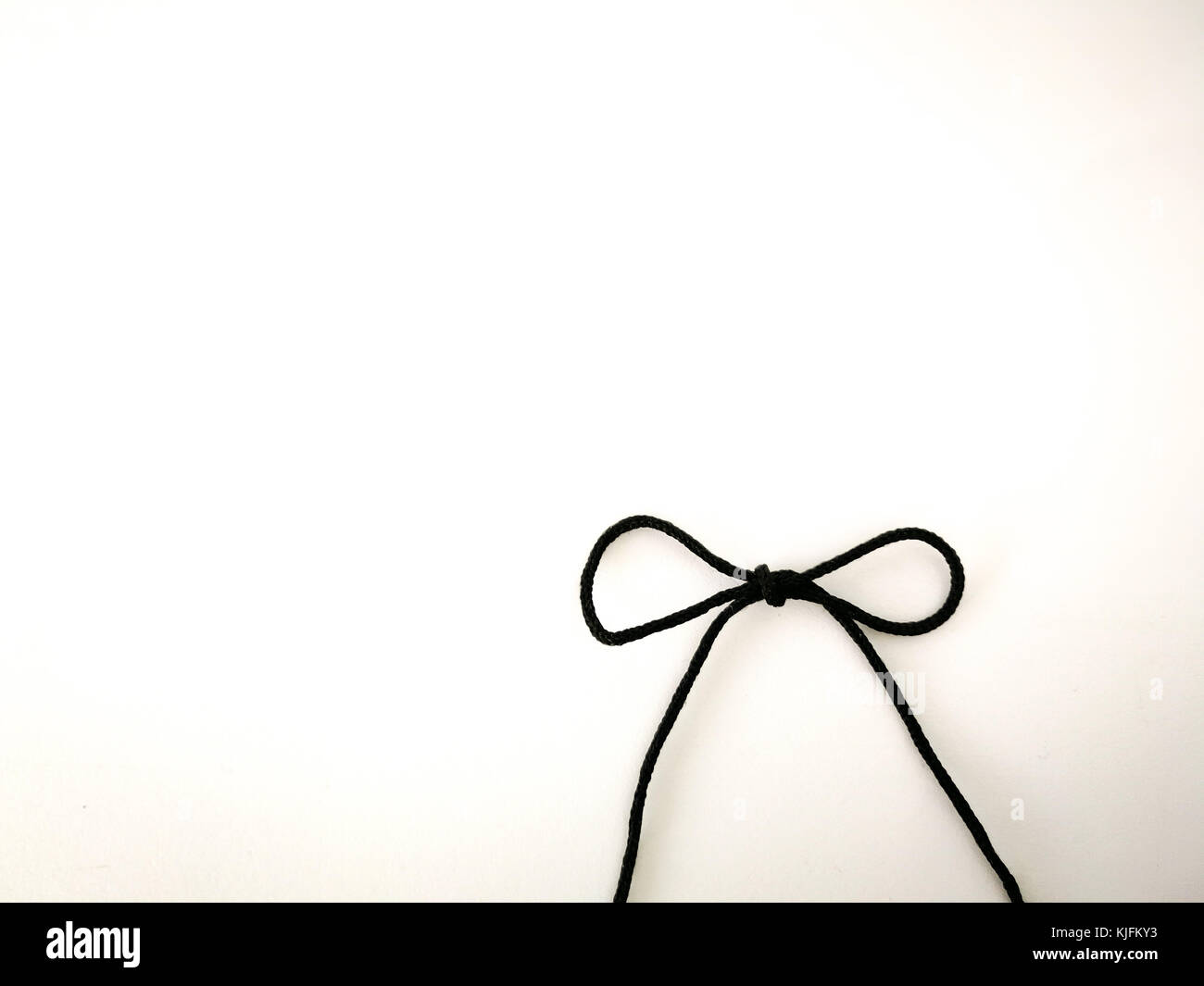 Rope bow black color on white isolated background. Stock Photo