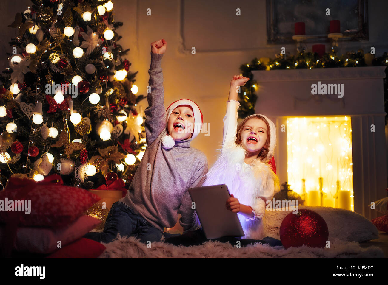 Excited children near Christmas tree Stock Photo