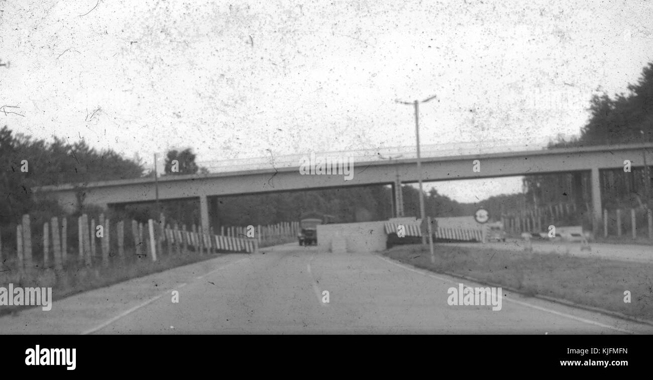 Blurred and damaged photo of military vehicles, cars and a highway overpass at a checkpoint on the border between East Berlin and West Berlin during the Cold War, taken secretly by an American tourist passing through the checkpoint, Germany, 1965. Stock Photo