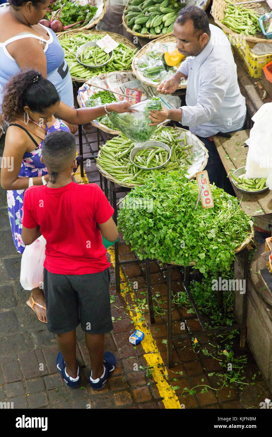 Customers buying vegetables at a market stall on the central market in Port Louis, Mauritius, Africa. Stock Photo