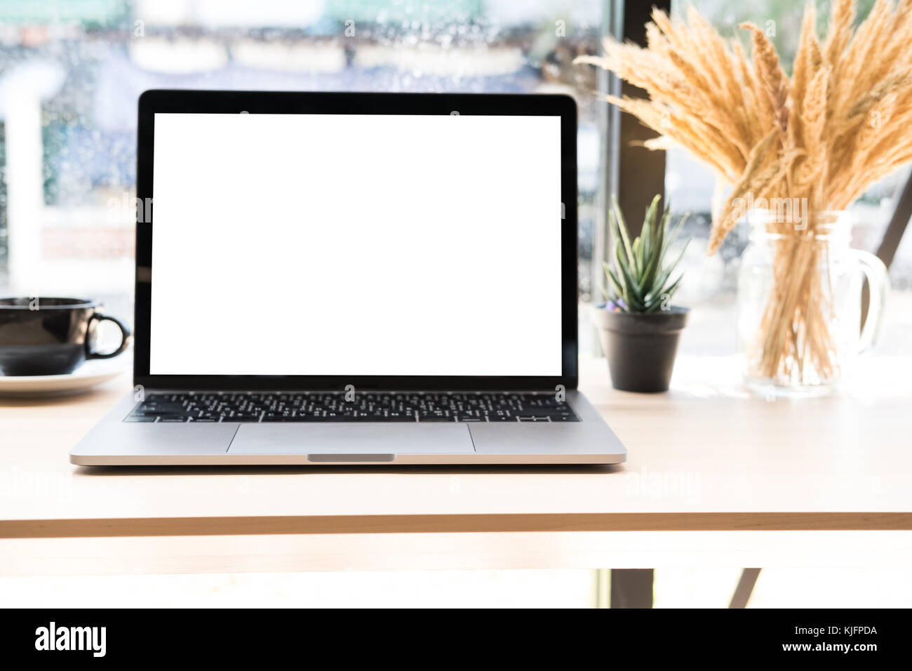 computer notebook, coffee cup on wood desk. laptop with blank screen at ...