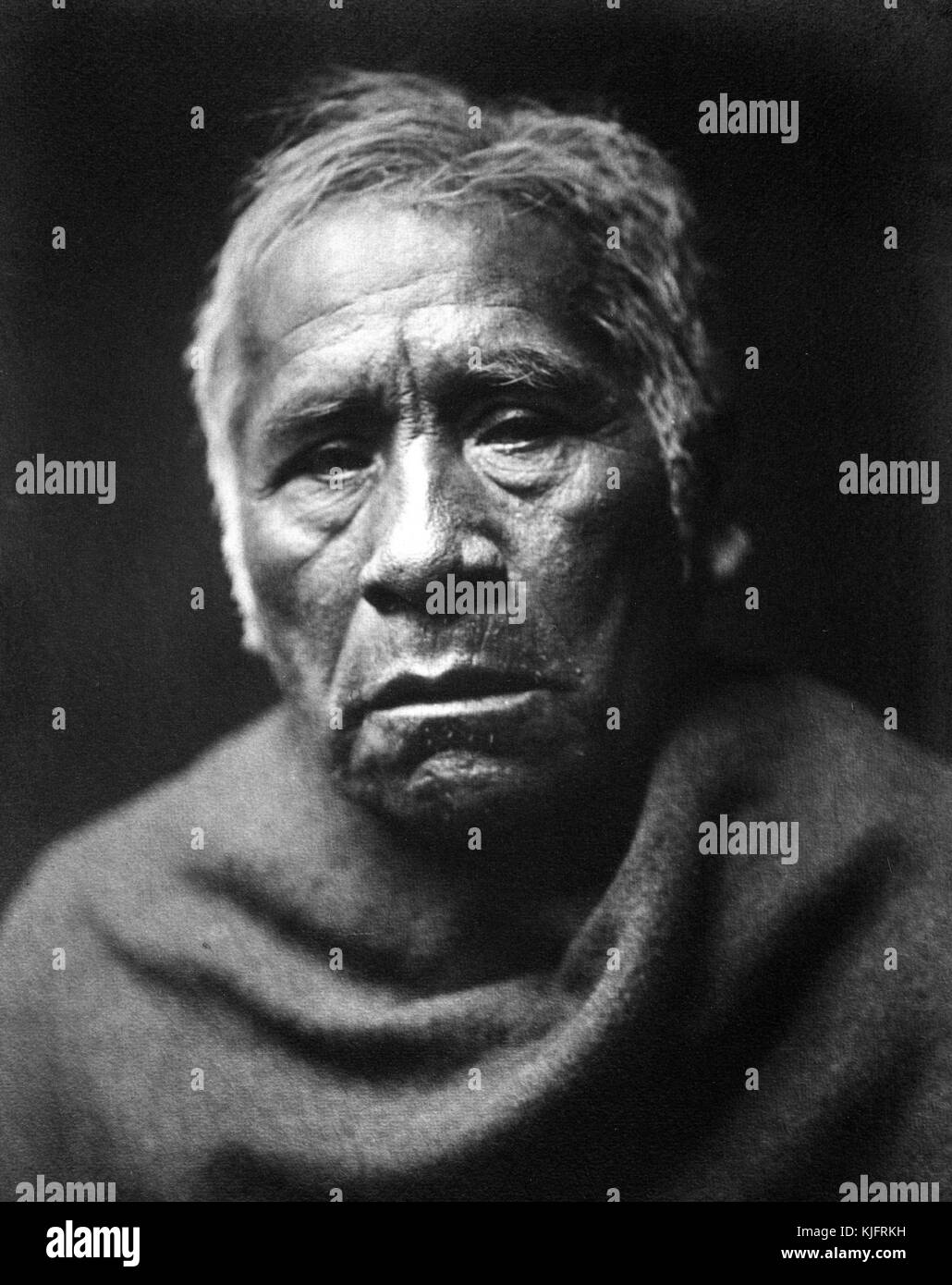 A photographic portrait of a Native American man identified as Captain Charley of Maracopa, he was an older man with greying hair, he was wearing a blanket or wrap around his shoulders for the portrait, 1907. From the New York Public Library. Stock Photo