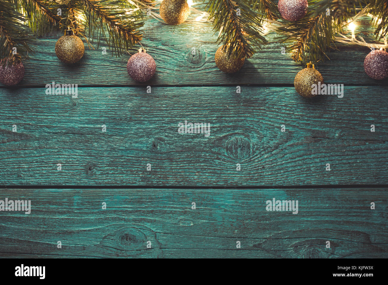 Image of blue wooden surface with burning New Year's garland, Christmas balls, spruce branches. Empty space for text Stock Photo