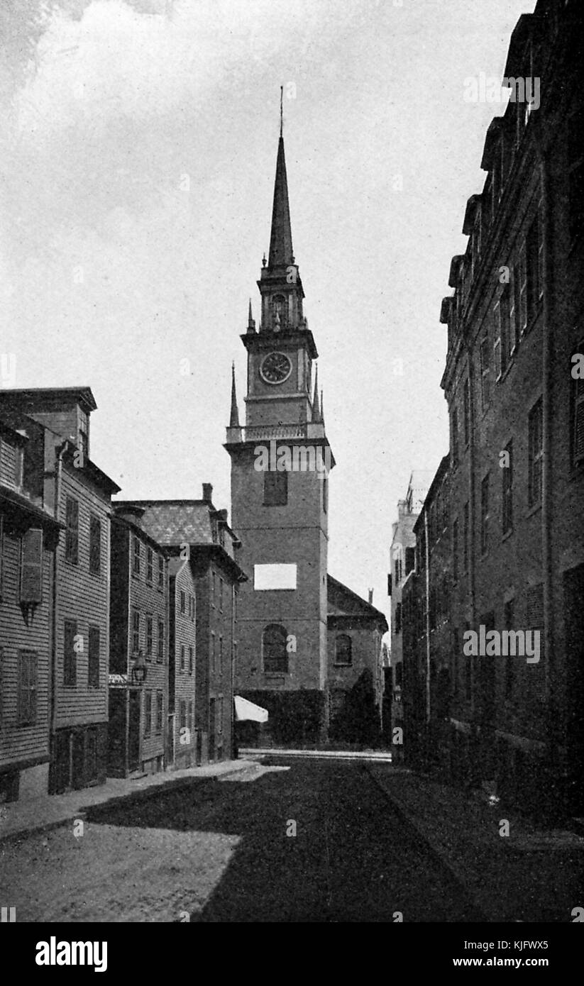 An exterior view of the Old North Church, it is the oldest standing church building in the city, it was the location of the 'One if by land, two if by sea' signal sent as part of Paul Revere's midnight ride, the photograph is composed so that the church is framed by two rows of buildings running down the sides of the street, it became a National Historic Landmark in 1961, Boston, Massachusetts, 1905. Stock Photo